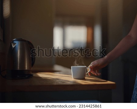 Woman is drinking coffee , morning routine. Tiny house. First property. Small apartment interior design. Minimalism. Moving in. Living alone. Charming trailer house with the morning sun