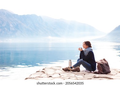 Woman drinking coffee and relaxing at sea beach. Winter picnic and rest - Powered by Shutterstock