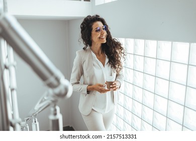 Woman drinking coffee as she's walking up the stairs. Going to work. Business woman walking in office and holding coffee cup. Ready, set, go get that success