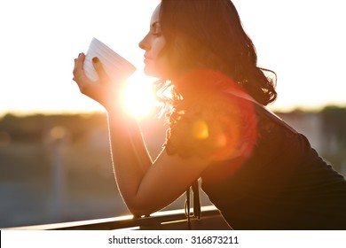 Woman Drinking Coffee In The Sun, Outdoor In Sunlight Light, Enjoying Her Morning Coffee.