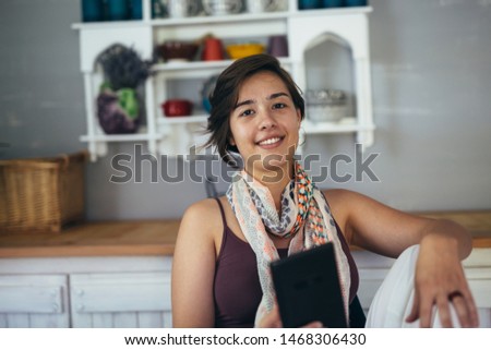 woman drinking coffee and using tablet at her home