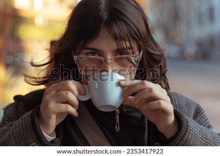 Woman drinking coffee while looking at the camera, cinematic looking