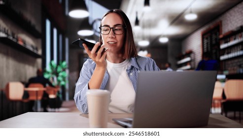 Woman Drinking Coffee And Working On Laptop. Sending Voice Message On Phone - Powered by Shutterstock