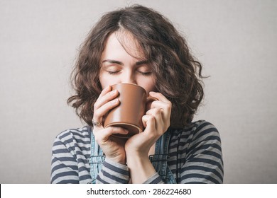 Woman Drinking A Cup Of Coffee Or Tea. Gray Background