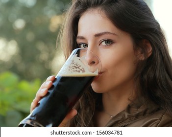 Woman Drinking Dark Beer Outdoor. Closeup Portrait