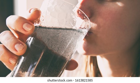 The Woman Is Drinking  Dirty Water From The Glass Cup