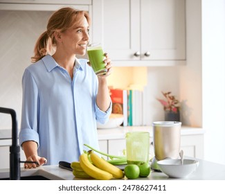 Woman Drinking Fresh Healthy Homemade Smoothie From Glass In Kitchen At Home - Powered by Shutterstock