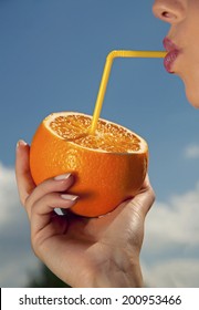woman drinking from a fresh orange juice