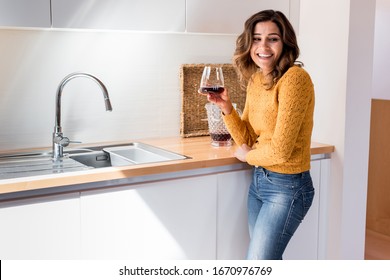 Woman Drinking A Glass Of Wine In A Modern Kitchen