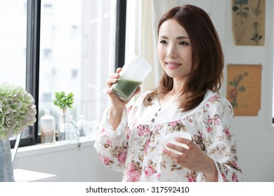 Woman Drinking Green Vegetable Smoothie