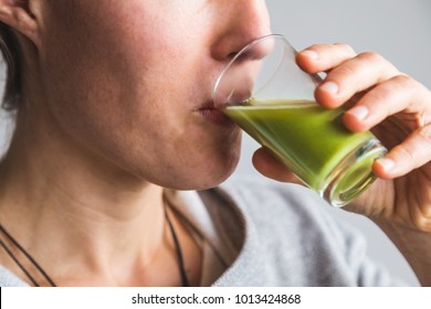 Woman Drinking Green Wheatgrass Juice Shot