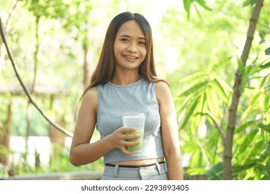 Woman drinking iced green tea in coffee cafe - Shutterstock ID 2293893405