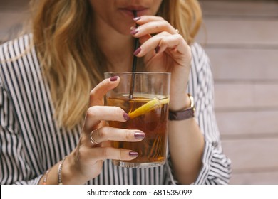 Woman Drinking Iced Tea With A Straw On A Restaurant