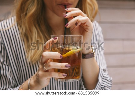 woman drinking iced tea with a straw on a restaurant