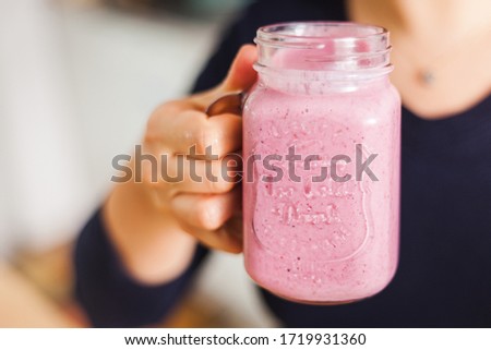 Similar – Mann hält einen Milchshake aus Beeren und Haferflocken.