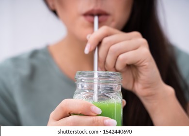 Woman Drinking Organic Smoothie Using Metal Straw