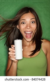 Woman drinking / showing blank can. Excited happy screaming girl holding energy drink or other drink. Asian / Caucasian female model on green background.
