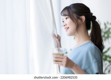 Woman Drinking A Smoothie By The Window