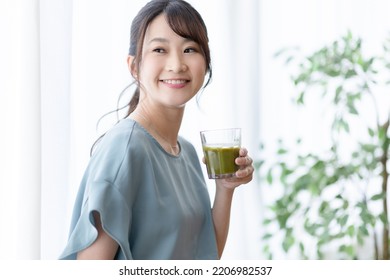 Woman Drinking A Smoothie By The Window