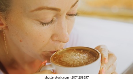 Woman drinking tasty beverages coffee Cappuccino Latte Art. Trav
