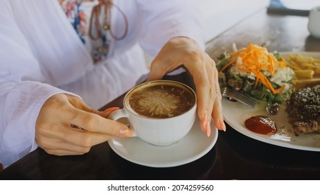 Woman drinking tasty beverages coffee Cappuccino Latte Art. Trav