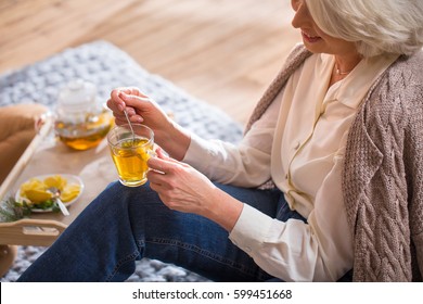 Woman Drinking Tea Sitting On The Floor Near Christmas Tree 