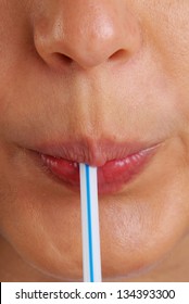 Woman drinking using a drinking  straw.