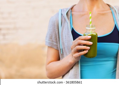 Woman drinking vegetable smoothie after fitness running workout on summer day. Fitness and healthy lifestyle concept - Powered by Shutterstock