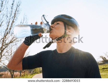Woman drinking water, bottle and cycling with fitness outdoor, helmet for safety and health with hydration. Athlete, biking and female with healthy and active lifestyle, wellness and sports training