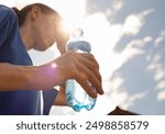 woman drinking water cooling off in extreme summer heat wave, person drinks from water bottle replenish fluids