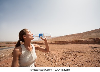 Woman Drinking Water In The Desert