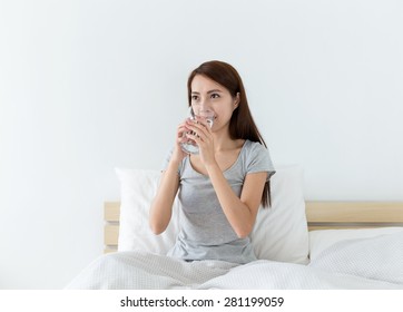 Woman Drinking Water On The Bed