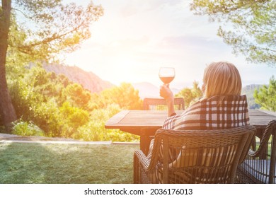 Woman Drinking Wine On The Terrace On A Sunny Fall Day. Girl Enjoys Nature And Fresh Air In A Plaid. Autumn Style.