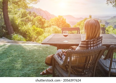 Woman Drinking Wine On The Terrace On A Sunny Fall Day. Girl Enjoys Nature And Fresh Air In A Plaid. Autumn Style.