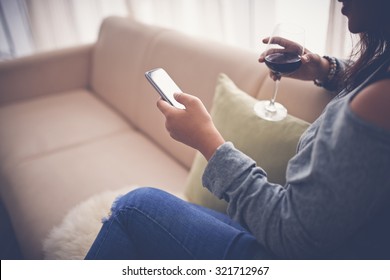 Woman drinking wine and text messaging at home - Powered by Shutterstock