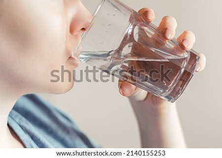 Woman drinks clean water. World Water Day. Health care concept. Diet and detox, increase metabolism. Hand holds drinking glass of water.