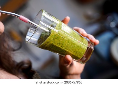 A Woman Drinks A Fruit Shake From A Metal Straw.