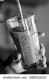 A Woman Drinks A Green Smoothie Fruit Shake Using A Metal Straw.