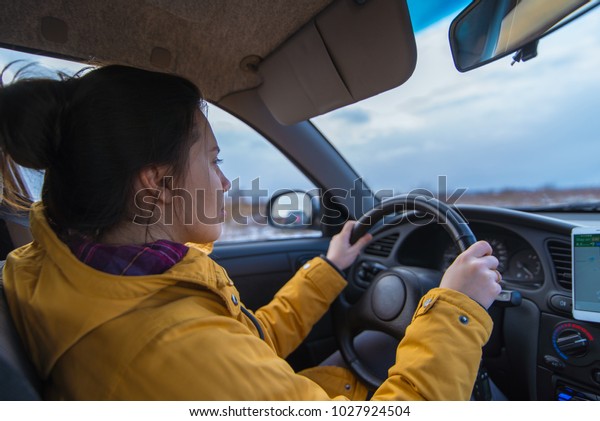 woman drive car in cold winter weather use\
phone for navigation
