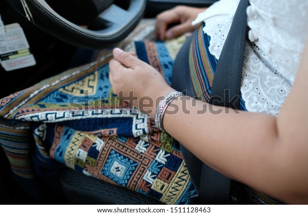 Woman drive the\
car ,hand with silver\
bracelets