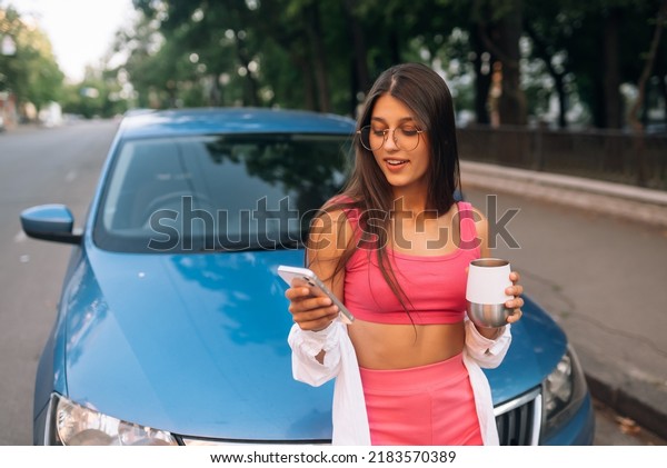 Woman\
drive car stop coffee break pause , use\
smartphone