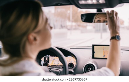 Woman driver adjusting the rear view mirror