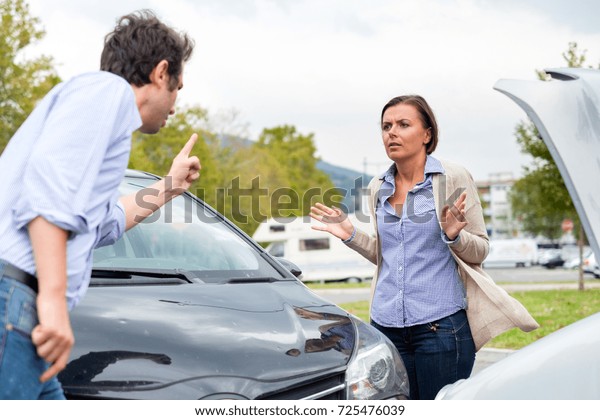 Woman driver and angry man arguing about the damage of\
the car 