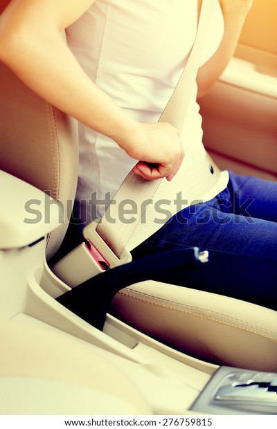 woman\
driver buckle up the seat belt before driving\
car