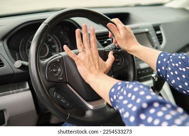 Woman driver hand honking her car horn to prevent accident. Driving safety concept - Shutterstock ID 2254533273