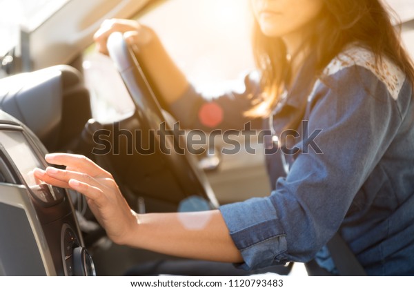woman\
driver hand touching the screen entering an address into the\
navigation system and turning on car radio\
system.