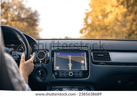 Woman driver hands on steering wheel inside car.