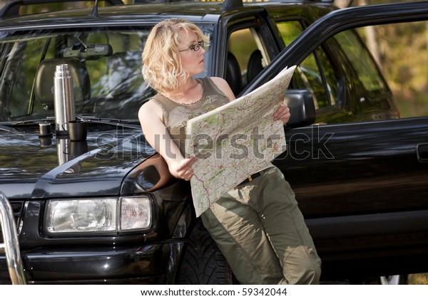 A woman driver reading a\
road map