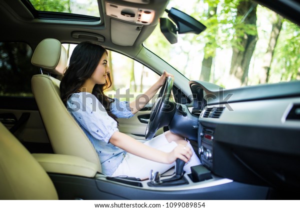 woman\
driver shifting the gear stick and driving a\
car