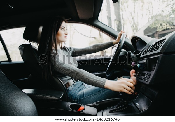 woman\
driver shifting the gear stick and driving a\
car